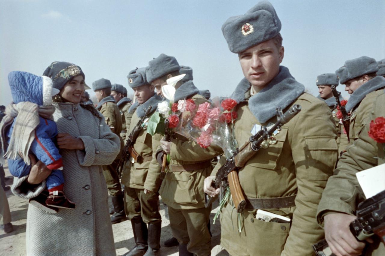 'Red Army soldiers are welcomed with flowers in Termez, Uzbekistan, after crossing the Amu Darya river at the Soviet-Afghan border on February 15, 1989  during Soviet Army withdrawal from Afghanistan.